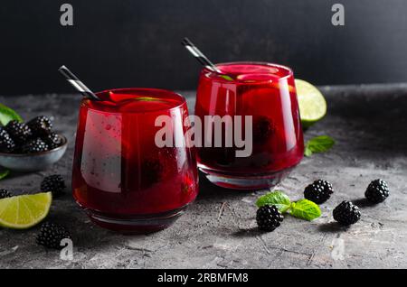Berry Lemonade, bevanda rinfrescante, cocktail, tè freddo, BlackBerry e Lime Summer drink su sfondo scuro Foto Stock