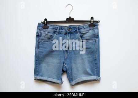 Shorts da uomo in denim su un appendiabiti bianco, abiti alla moda Foto Stock