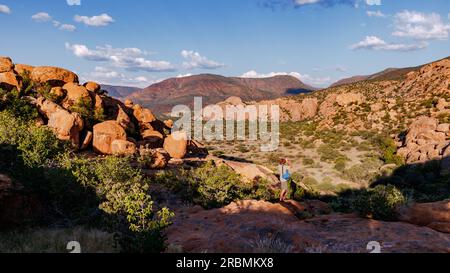 Un turista guarda lo splendido paesaggio roccioso nelle panoramiche montagne Erongo in Namibia al tramonto, in Africa Foto Stock