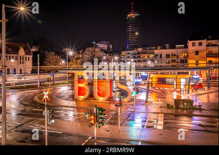 Vista della stazione degli autobus di Jena e di Jentower sullo sfondo con la lunga esposizione di un tram di notte, Jena, Turingia, Germania Foto Stock