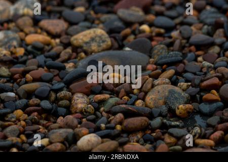 Un astratto di alcuni ciottoli bagnati lungo la costa di Whitefish Point Bay nel Michigan, Stati Uniti. Foto Stock