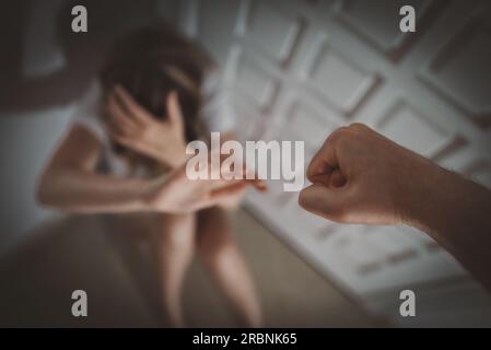 L'uomo batte la donna con il pugno. Vittima di violenza domestica. Foto Stock