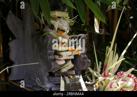 Canang sari, contenitore di bambù intessuto con riso, fiori, incenso, dolci e frutta. Si tratta di un'offerta agli dei, come gesto di gratitudine a Bali Foto Stock