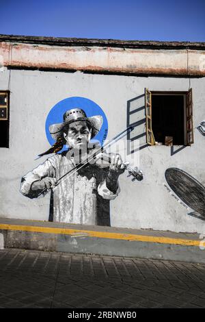 Tradizionalmente vestito, suona il violino su un murale, città di Oaxaca de Juárez, stato di Oaxaca, Messico, Nord America, America Latina Foto Stock