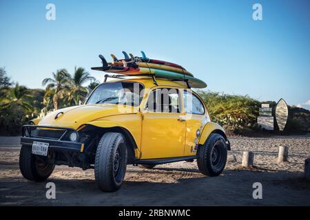 VW Beetle per fuoristrada con tavole da surf sul tetto al posto di surf a Playa Zicatela, Puerto Escondido, Oaxaca, Messico, Nord America, Latin Amer Foto Stock