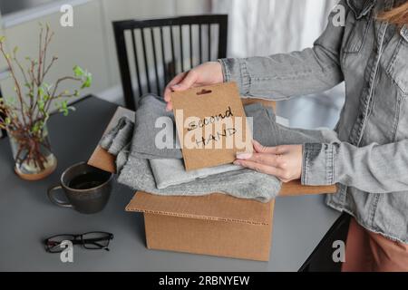 Donna imballaggio scatola con abiti usati per la rivendita Foto Stock