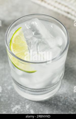 Acqua rinfrescante fredda con calce in un bicchiere Foto Stock