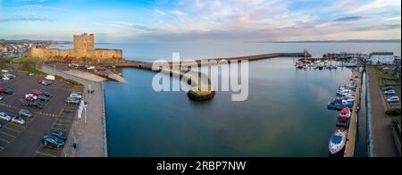 Carrickfergus vicino a Belfast, Irlanda del Nord, Regno Unito. Ampio panorama aereo del castello normanno medievale, porto turistico con yacht, rampa di accesso, frangiflutti e Belfa Foto Stock