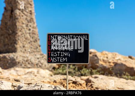 Simbolo IELTS. Concetto di parola IELTS sistema internazionale di test in lingua inglese su lavagna nera. Splendido sfondo in pietra. Business IELTS intern Foto Stock