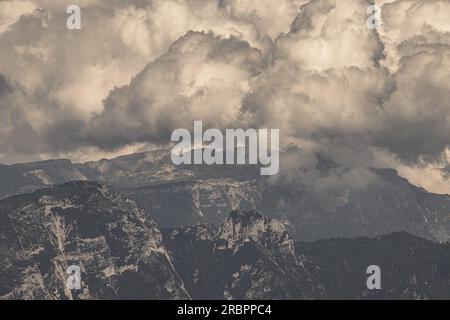 Montagne mistiche drappeggiate da nuvole vorticose, un'immagine artistica mozzafiato che mostra l'incantevole abbraccio del velo etereo della natura. Un accattivante Foto Stock