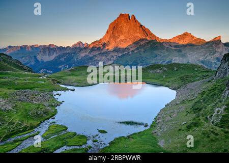 Alpenglow a PIC du Midi con lago di montagna in primo piano, Vallee d'39; Ossau, Parco Nazionale dei Pirenei, Pirenei, Francia Foto Stock