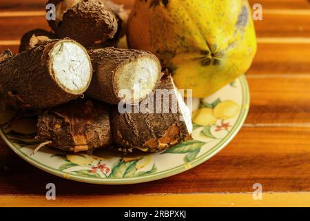 Papaya e manioca in un bellissimo piatto fiorito sul tavolo Foto Stock