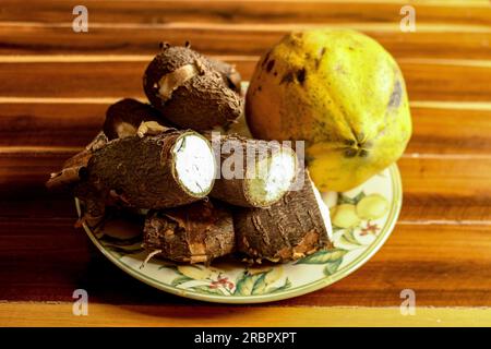 Papaya e manioca in un bellissimo piatto fiorito sul tavolo Foto Stock