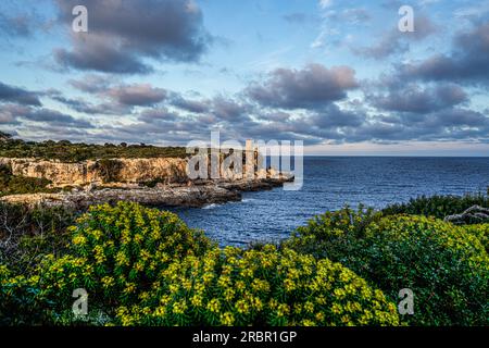 Atmosfera serale in riva al mare: Vista dall'alta costa alla baia di Cala Figuera e alla Torre d'en Beu, Santanyí, Maiorca, Spagna Foto Stock