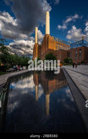 Battersea, Londra, Regno Unito: La centrale elettrica di Battersea è ora riqualificata come destinazione per lo shopping e il tempo libero. Ampio angolo di visione serale con riflesso Foto Stock