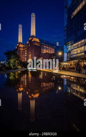 Battersea, Londra, Regno Unito: La centrale elettrica di Battersea è ora riqualificata come destinazione per lo shopping e il tempo libero. Ampio angolo di visione notturna con riflesso Foto Stock