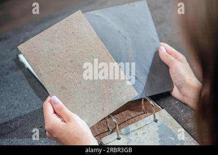 Primi piani di campioni di pietra artificiale nelle mani. Inserti in pietra naturale per la finitura di elementi interni e mobili. Foto Stock