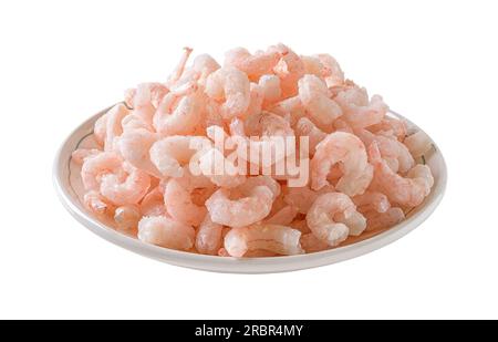 Cumulo di gamberetti bolliti congelati su un'apertura della piastra. Piatto di code di gamberi cotte sbucciate isolato su sfondo bianco. Gamberetti surgelati preparati per la cottura. Foto Stock