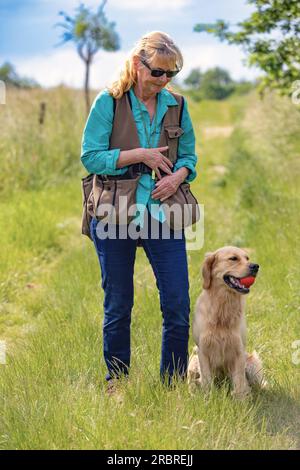 Donna che indossa un manichino e il suo obbediente Golden retriever Foto Stock