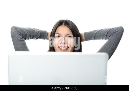 Bella donna sorridente che si rilassa con le mani dietro la testa mentre guarda in alto, dopo che il computer funziona. Isolato su sfondo bianco Foto Stock