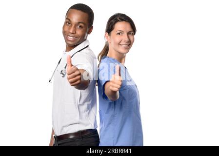 Team medico multietnico di successo entusiasta con un medico africano sorridente e la sua bella infermiera o assistente che dà un pollice su gesto con Foto Stock