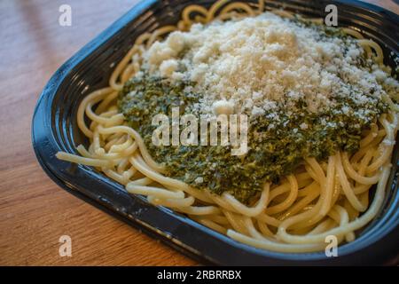 Assaggia la freschezza degli spaghetti italiani soffocati in una deliziosa salsa di spinaci e conditi con parmigiano. Foto Stock