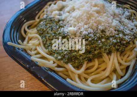 Assaggia la freschezza degli spaghetti italiani soffocati in una deliziosa salsa di spinaci e conditi con parmigiano. Foto Stock