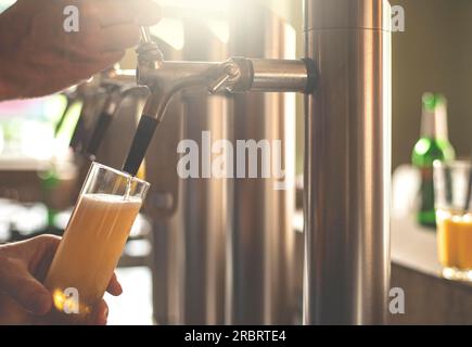 Un padrone di casa prende la birra in un bar Foto Stock