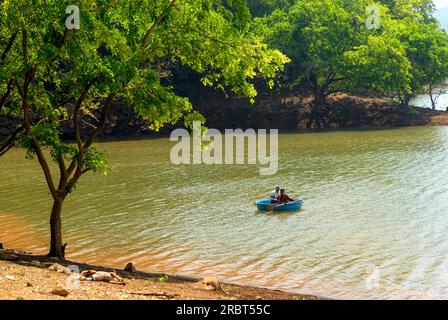 I turisti che si godono il giro a coracle presso il punto turistico ecologico di Baralikkadu si trovano presso la diga di Karamadai Pilloor, la catena di Athikkadavu dei Ghati occidentali a Mulli Foto Stock