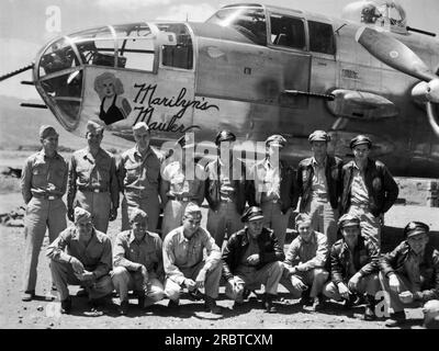 Se Asia: c. 1943 l'equipaggio di un bombardiere B-25 chiamato "Marilyn's Mauler" si pone accanto ad esso da qualche parte nel teatro del Pacifico durante la seconda guerra mondiale. Foto Stock