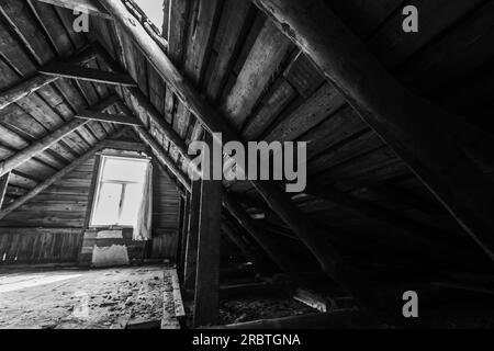 Interni astratti in legno grunge scuri, vista prospettica di un attico abbandonato con finestra luminosa, foto in bianco e nero Foto Stock