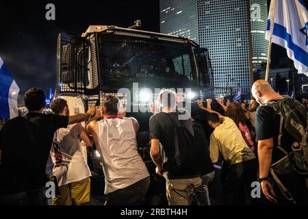 Tel Aviv, Israele. 5 luglio 2023. I manifestanti anti-riforma israeliani tentano di bloccare un cannone ad acqua della polizia sulla strada bloccata di Ayalon durante la manifestazione. Migliaia di israeliani sono scesi in strada e hanno bloccato l'autostrada Ayalon a Tel Aviv scontrandosi con la polizia che ha usato cannoni ad acqua e ufficiali di polizia a cavallo e arresti per disperdere i manifestanti dopo che il capo della polizia di Tel Aviv Amichai Eshed ha annunciato le sue dimissioni dalla forza. (Immagine di credito: © Matan Golan/SOPA Images via ZUMA Press Wire) SOLO USO EDITORIALE! Non per USO commerciale! Foto Stock