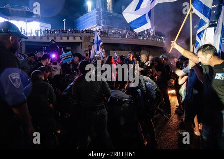 Tel Aviv, Israele. 6 luglio 2023. I soldati della polizia di frontiera israeliana rimuovono i manifestanti anti-riforma dalla strada bloccata di Ayalon durante la manifestazione. Migliaia di israeliani sono scesi in strada e hanno bloccato l'autostrada Ayalon a Tel Aviv scontrandosi con la polizia che ha usato cannoni ad acqua e ufficiali di polizia a cavallo e arresti per disperdere i manifestanti dopo che il capo della polizia di Tel Aviv Amichai Eshed ha annunciato le sue dimissioni dalla forza. (Immagine di credito: © Matan Golan/SOPA Images via ZUMA Press Wire) SOLO USO EDITORIALE! Non per USO commerciale! Foto Stock