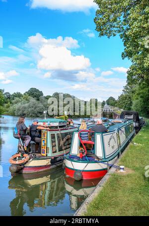 I narrowboat ai piedi della chiusa di Caen Hill volano vicino a Devizes, Wiltshire, Regno Unito. Foto Stock