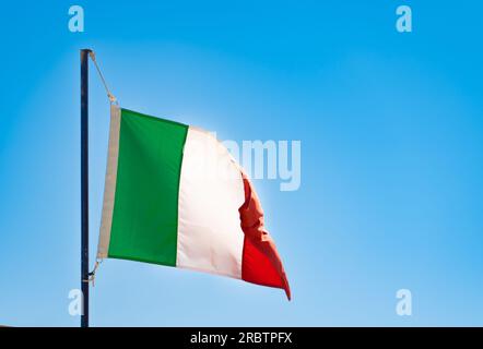 Bandiera italiana su un cielo blu, problemi, concetto di recessione ilaty, bandiera d'Italia Foto Stock