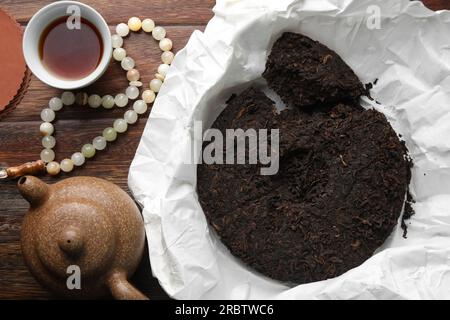 Composizione piatta con tè pu-erh su tavolo in legno Foto Stock