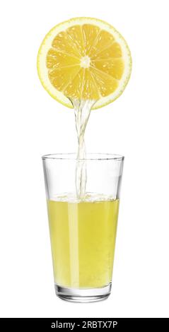 Versare il succo appena spremuto dal limone nel bicchiere su sfondo bianco Foto Stock