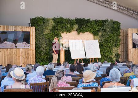I visitatori del RHS Hampton Court Flower Show di Londra ascoltano il giardiniere televisivo Joe Swift Foto Stock