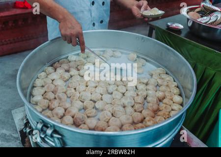 Tradizionale e molto popolare cibo nepalese. Nepalese al vapore gnocchi momo che cucinano e servono alla festa. Immagine ravvicinata. Foto Stock