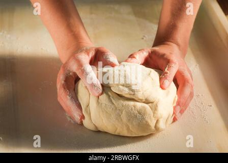 Le mani fanno l'impasto. Fai pierogi varenky ai gnocchi di mirtilli a casa tua, passo dopo passo. Processo di preparazione tradizionale polacco estivo o piatto ucraino wi Foto Stock