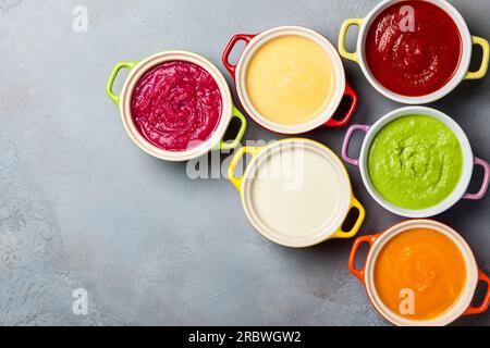 Varieta' di minestre di verdure colorate con panna in pentole piccole. Vista dall'alto. Concetto di alimentazione sana o cibo vegetariano. Foto Stock