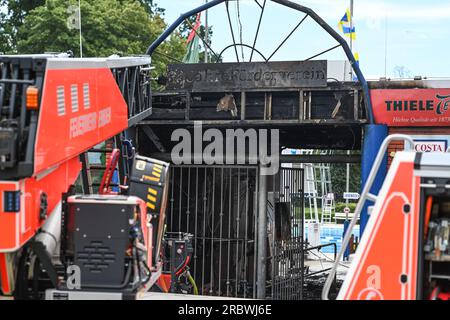 Emden, Germania. 11 luglio 2023. La scala girevole dei vigili del fuoco si trova di fronte all'ingresso della piscina all'aperto, sul cui terreno si è bruciato un edificio. Un incendio alla piscina Van Ameren di Emden ha causato un'operazione importante. L'incendio ha causato danni di circa due milioni di euro. L'operazione di balneazione del bagno van Ameren fino a non sarà possibile fino a nuovo avviso. Crediti: Lars Penning (klemmer)/dpa/Alamy Live News Foto Stock