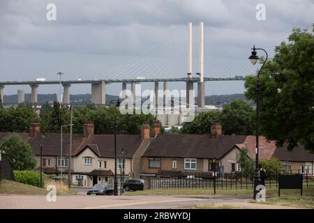 Il Queen Elizabeth II Bridge sul Tamigi (Dartford Crossing), visto in lontananza da Purfleet-on-Thames. Case suburbane in primo piano. Foto Stock