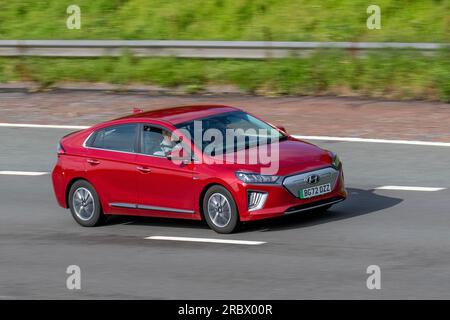 2022 Red Hyundai Ioniq Premium EV, 134 38 kWh Auto Red Car Hatchback elettricità potenza 100 kW; viaggia a velocità sostenuta sull'autostrada M6 a Greater Manchester, Regno Unito Foto Stock