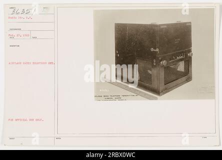 Immagine: Una fotografia in bianco e nero che mostra un funzionario militare che tiene un apparecchio radio-telefono a forma di cubo su un aeroplano munizioni. Il set è contrassegnato con il numero di identificazione 036351 ed è destinato esclusivamente all'uso ufficiale. La foto è stata scattata da un fotografo della radio Division il 15 febbraio 1919. Foto Stock