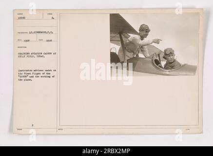 Un cadetto di aviazione riceve istruzioni da un istruttore prima di imbarcarsi per il suo primo volo a Kelly Field in Texas. L'istruttore lo guida sulle "donts" e spiega il funzionamento dell'aereo. Questa fotografia, scattata nel 1918, cattura le attività di addestramento per i cadetti dell'aviazione durante la prima guerra mondiale a Kelly Field. Foto Stock