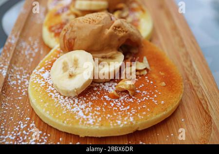 Primo piano di noci tritate con banane a fette, condimenti sani di pancaked Foto Stock