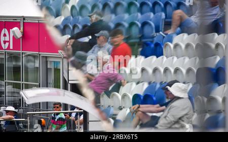 Hove UK 11 luglio 2023 - gli spettatori si riflettono in una finestra gigante mentre il Sussex affronta il Derbyshire durante il secondo giorno della partita di cricket del campionato LV= Insurance County al 1st Central County Ground di Hove : Credit Simon Dack /TPI/ Alamy Live News Foto Stock