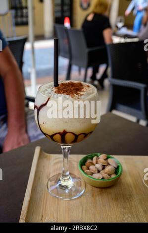 Glass di caffè ghiacciato frappuccino con panna montata, cioccolato e cubetti di ghiaccio serviti nella caffetteria all'aperto di Oviedo, Asturias, Spagna Foto Stock