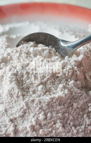 vista ravvicinata della farina di riso con cucchiaio, forma di farina a base di chicchi di riso finemente macinati, sostituto naturale senza glutine della farina di frumento Foto Stock